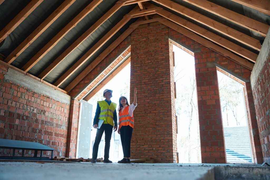 Woman architect consulting main construction worker about finishing works